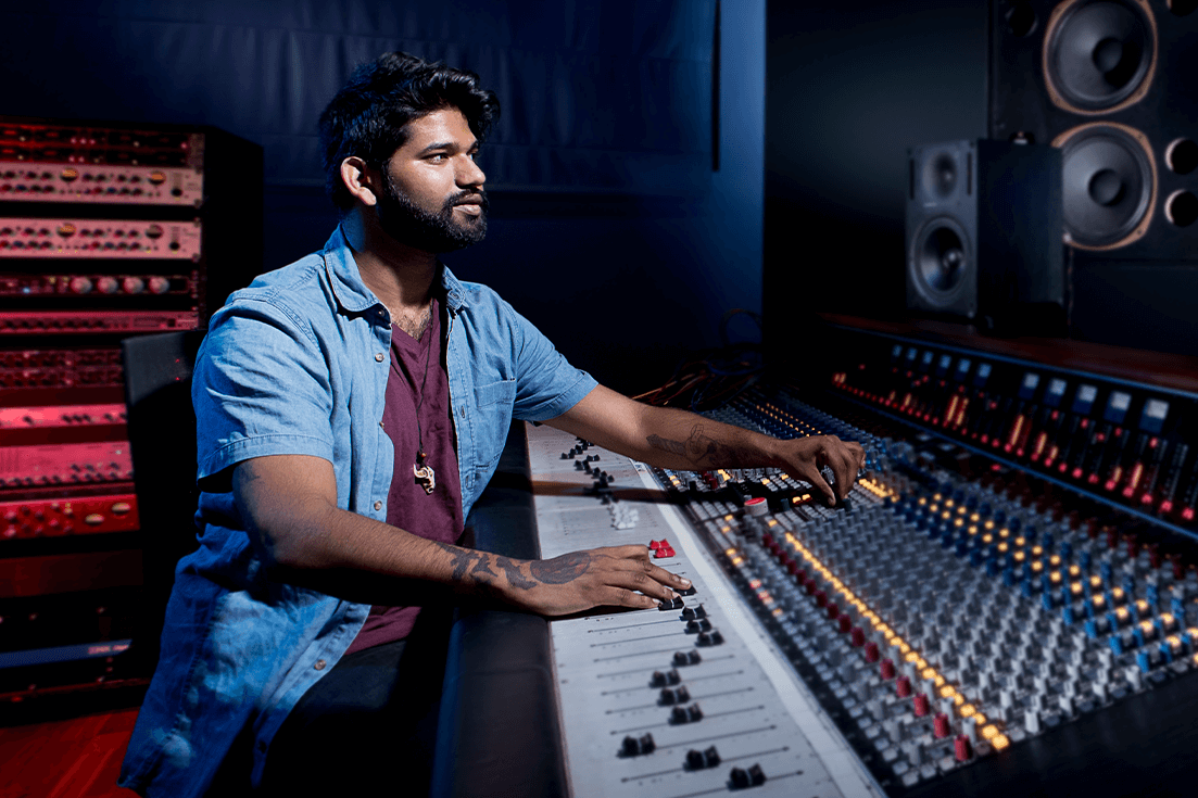 Bearded man working on an audio desk